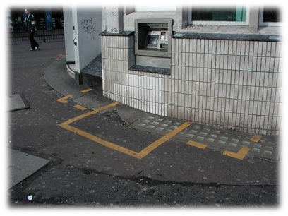 ATM with yellow privacy box painted on the footway